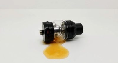 Close-up of a disposable vape leaking e-liquid near the airflow hole.